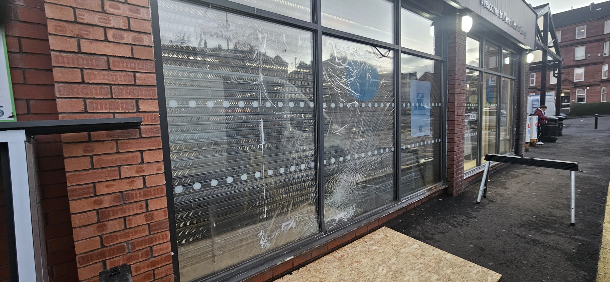 Damaged shopfront glazing prior to emergency board-up and replacement