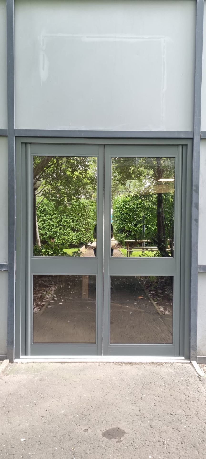 Aluminium-framed double doors with full glazing onto landscaped grounds