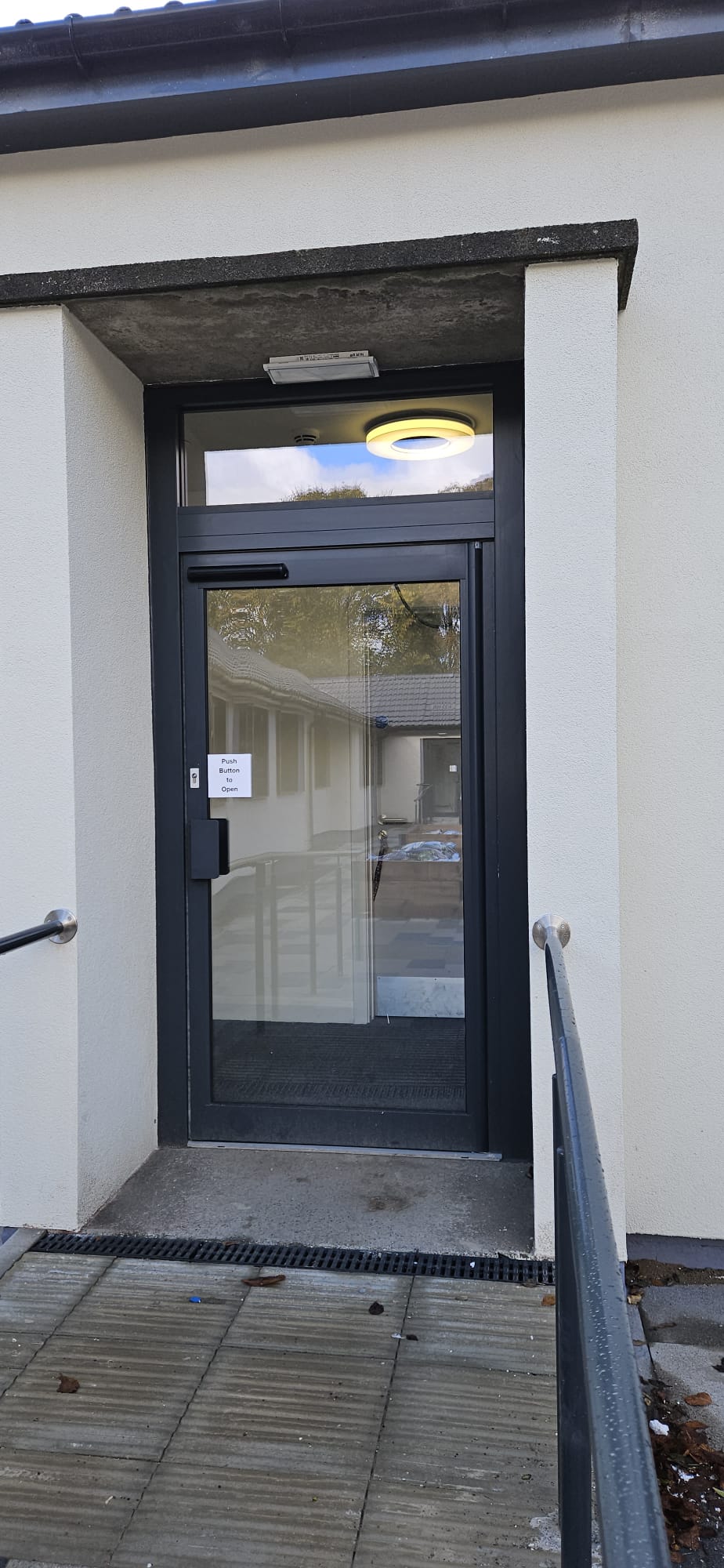 Single anthracite aluminium-framed automatic entrance door with FAAC overhead operator