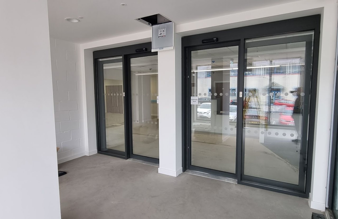 Complete Door Solutions engineer installing a commercial automatic sliding door in Glasgow