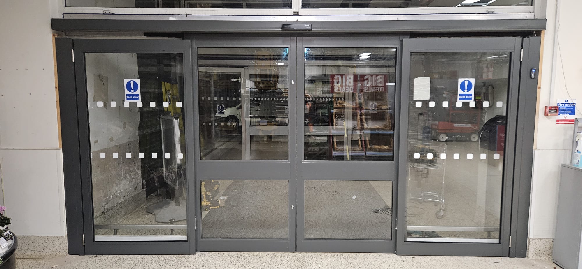 Anthracite aluminium-framed shopfront with sliding entry panels and full glazing