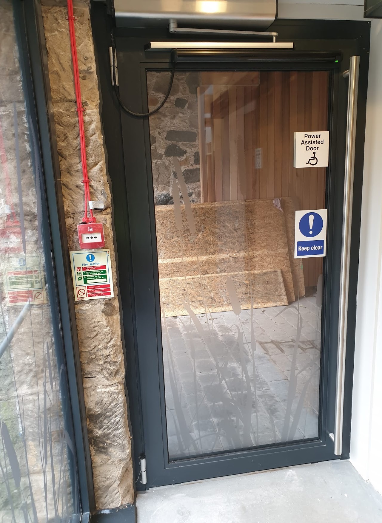 Power-assisted single-leaf glazed door, heritage stone entrance