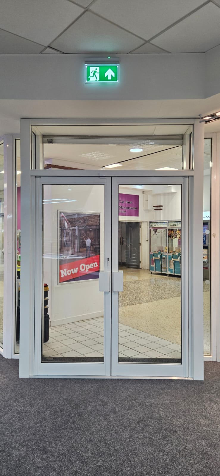 Pair of aluminium glazed fire-rated doors at shopping centre entrance — Now Open